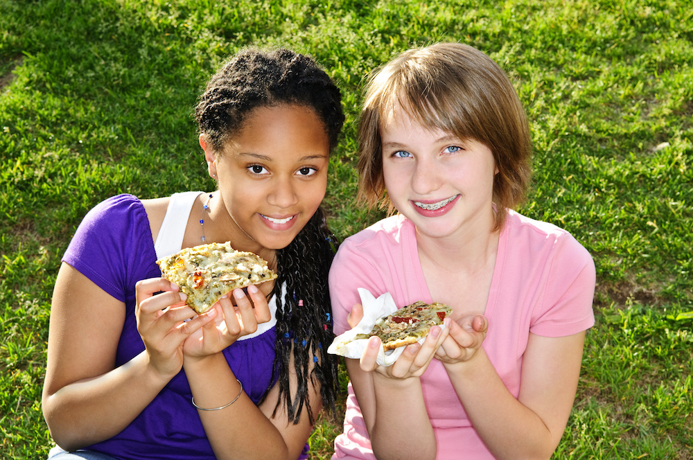 Girls eating pizza Use these braces-safe lunch ideas to keep your teens well-fed in Charleston SC