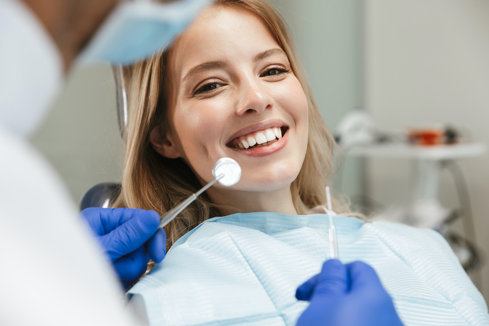 Image of satisfied woman sitting in dental chair while professional doctor fixing her teeth Don't wait for your dentist to refer you to an orthodontist in Charleston SC